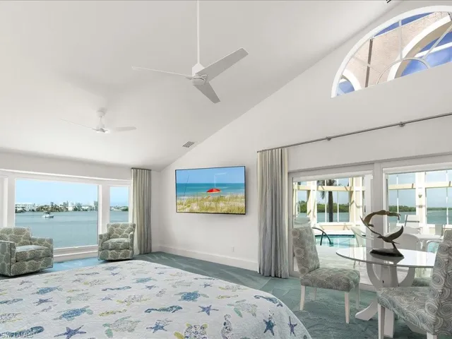 Bedroom with visible vents, high vaulted ceiling, carpet flooring, baseboards, and ceiling fan