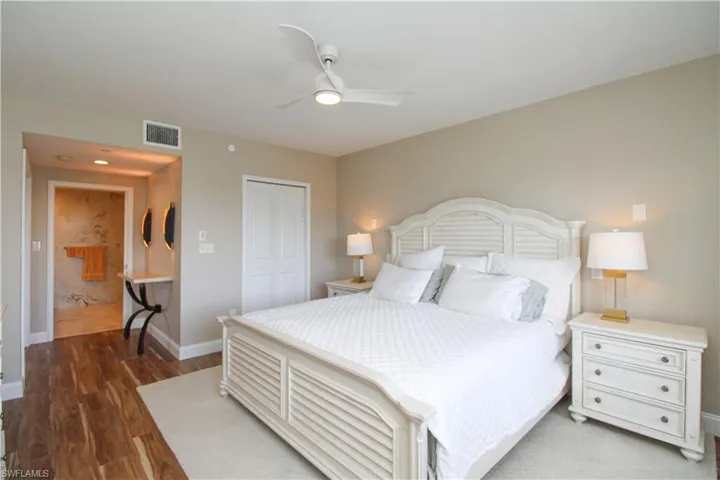 Bedroom with a closet, ceiling fan, and dark wood-type flooring