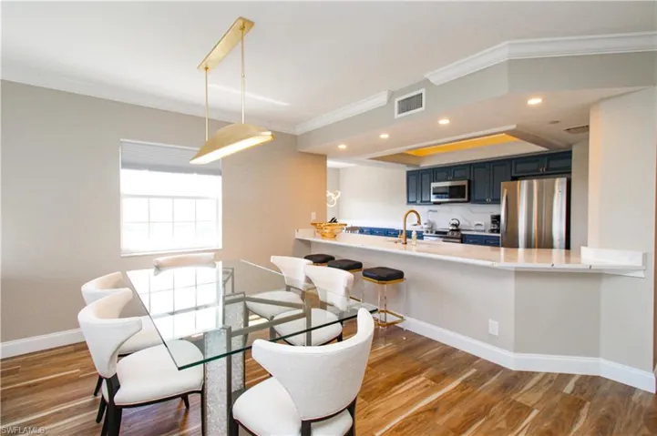 Dining room featuring ornamental molding, sink, and dark hardwood / wood-style flooring