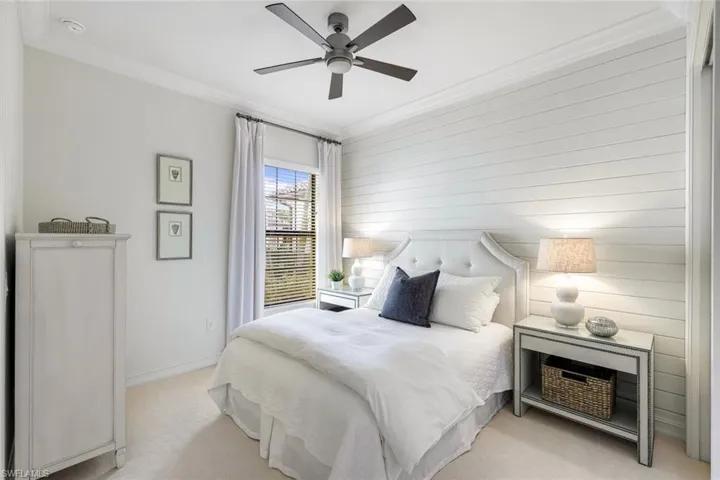 Carpeted bedroom featuring crown molding and ceiling fan