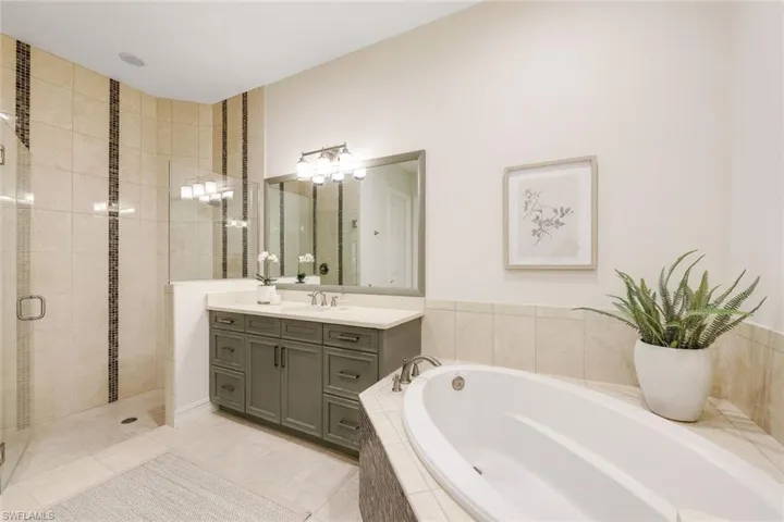 Bathroom featuring tile patterned floors, vanity, and independent shower and bath