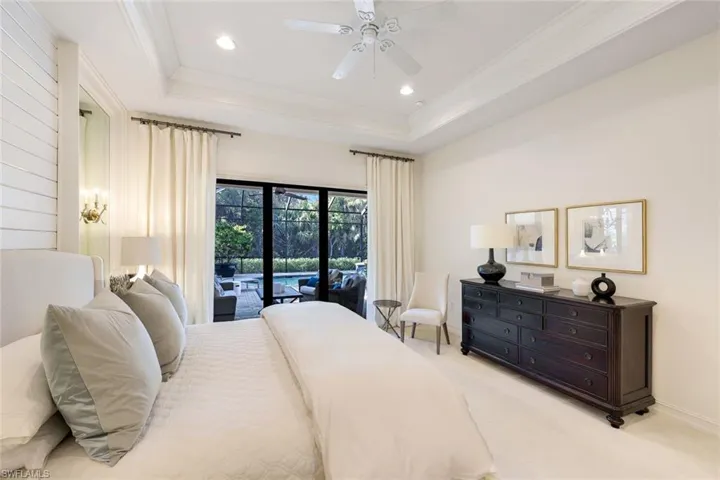 Bedroom featuring crown molding, light carpet, a tray ceiling, ceiling fan, and access to exterior