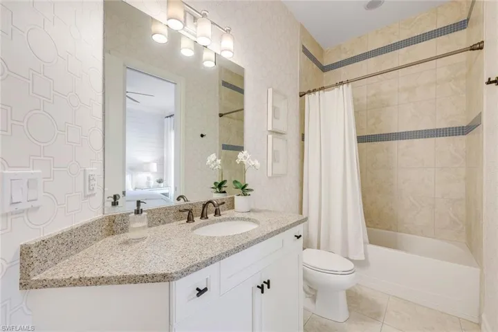 Full bathroom featuring tile patterned flooring, vanity, shower / bath combination with curtain, and toilet