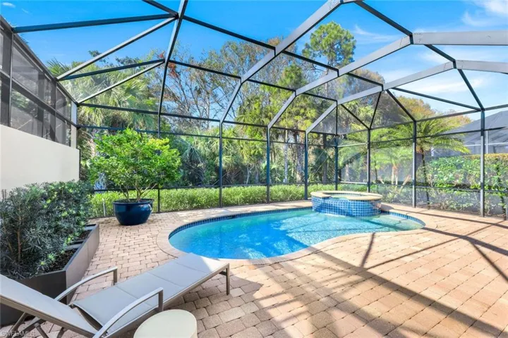 View of swimming pool featuring an in ground hot tub, a patio, and glass enclosure