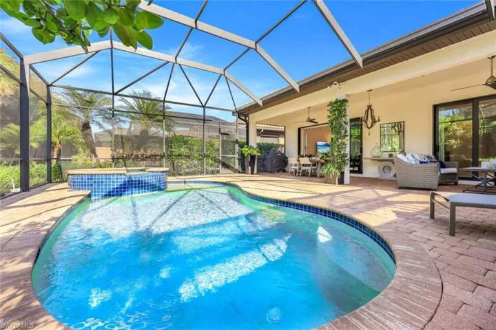 View of pool with a lanai, an outdoor hangout area, ceiling fan, and a patio area