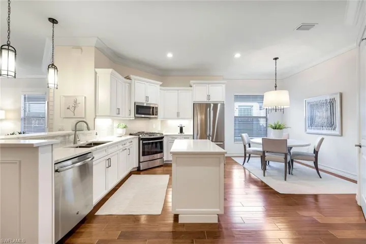 Kitchen featuring a center island, hanging light fixtures, sink, and appliances with stainless steel finishes