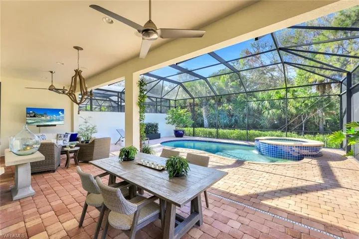 View of patio featuring a pool with hot tub, an outdoor living space, and a lanai