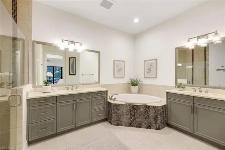 Bathroom featuring tile patterned flooring, shower with separate bathtub, and vanity