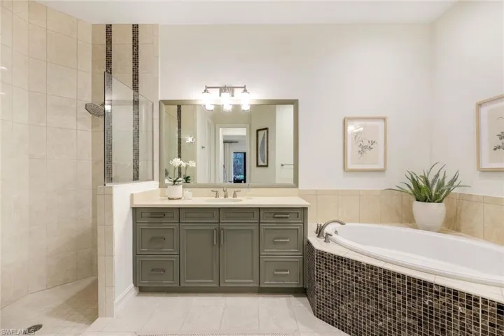 Bathroom featuring vanity, shower with separate bathtub, and tile patterned floors