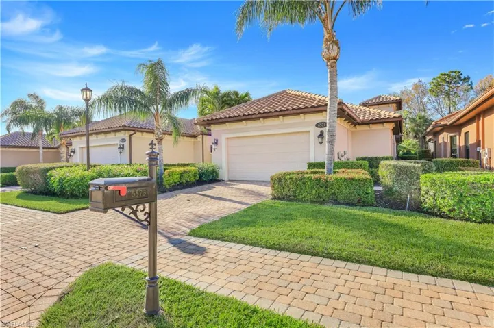 Mediterranean / spanish home featuring a garage and a front yard
