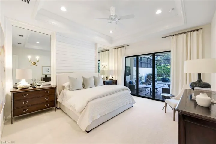Carpeted bedroom featuring ornamental molding, access to outside, ceiling fan, and a tray ceiling