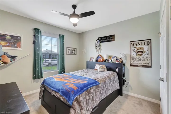 Bedroom featuring light carpet, baseboards, and a ceiling fan