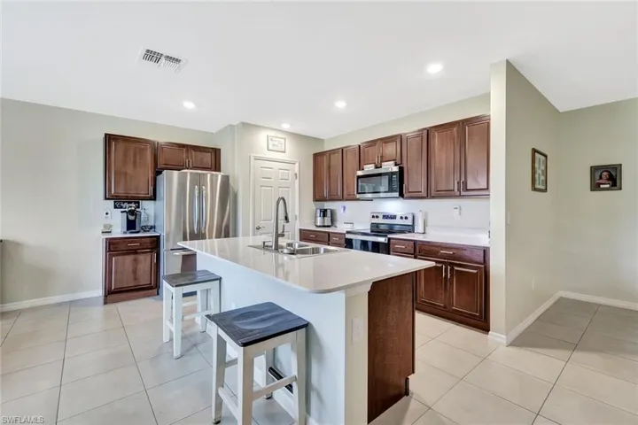 Kitchen featuring a sink, visible vents, light tile patterned floors, and appliances with stainless steel finishes