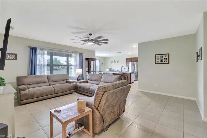 Living area with baseboards, ceiling fan, recessed lighting, and light tile patterned floors