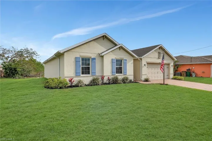 Single story home with driveway, a front yard, an attached garage, and stucco siding