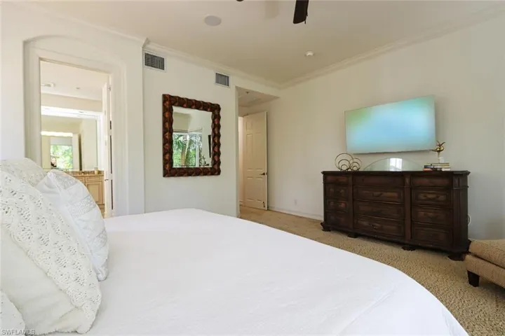 Bedroom featuring carpet, ornamental molding, ceiling fan, and connected bathroom