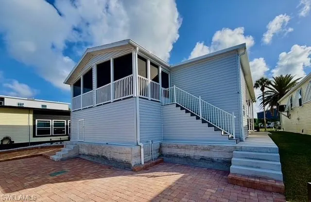 Back of property with a patio and a sunroom