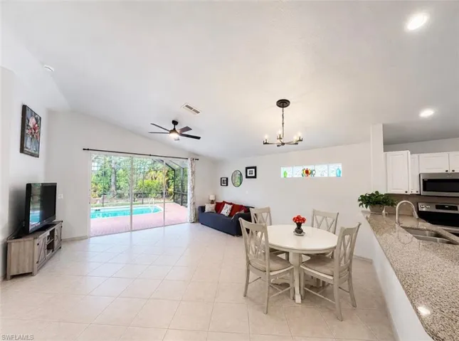 Open concept living area with vaulted ceilings and tile flooring