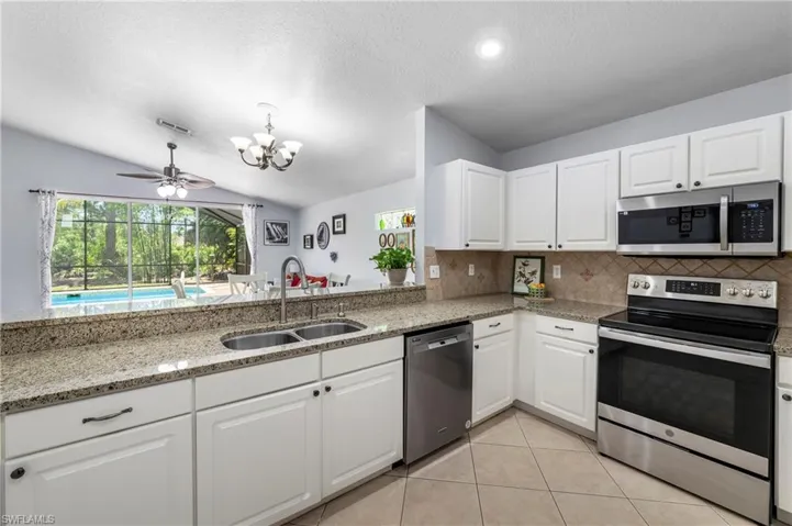 Kitchen featuring white cabinetry, granite countertops, and stainless steel appliances