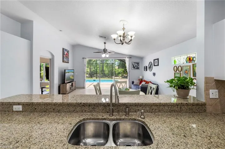 Kitchen pass-through featuring dual stainless steel sinks and light granite-finish countertops