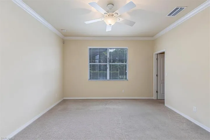 Unfurnished room with light colored carpet, ornamental molding, and a ceiling fan