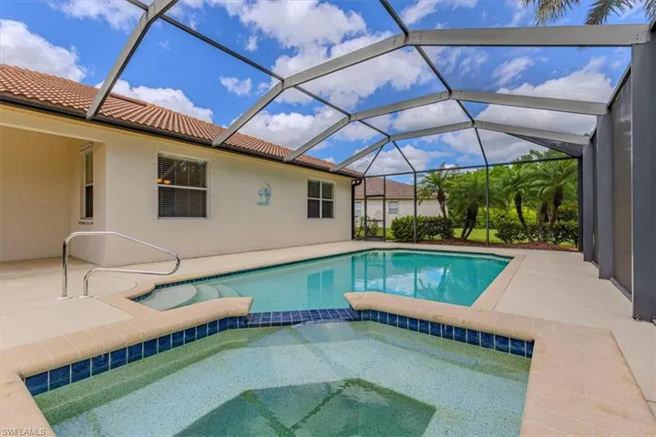 View of pool with a patio, a sunroom, a lanai, and a pool with connected hot tub