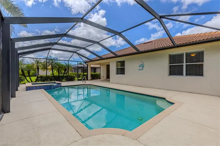 View of pool with a patio, a sunroom, a lanai, and a pool with connected hot tub