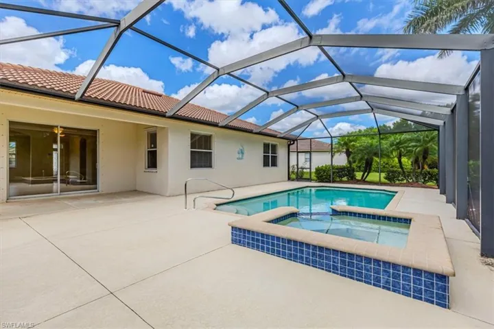 View of pool with a patio area, a sunroom, a lanai, and a pool with connected hot tub