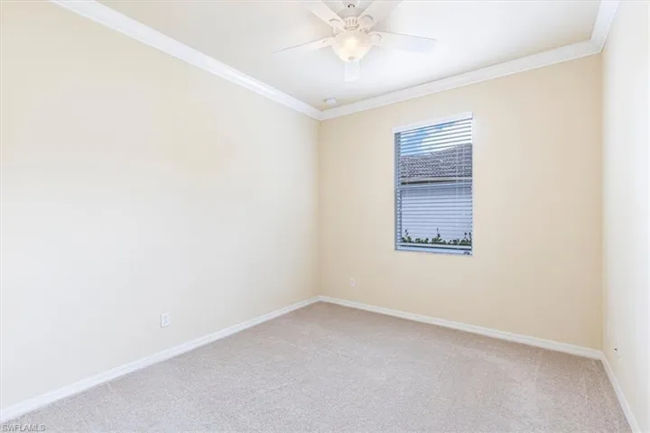 Spare room featuring crown molding and light carpet