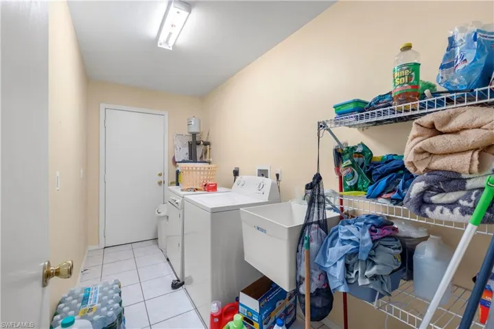 Laundry room featuring washing machine and clothes dryer and light tile patterned floors