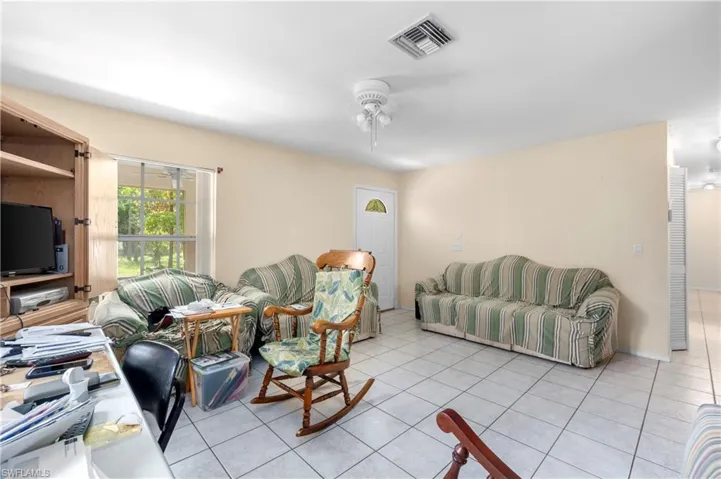 Living room with ceiling fan and light tile patterned floors