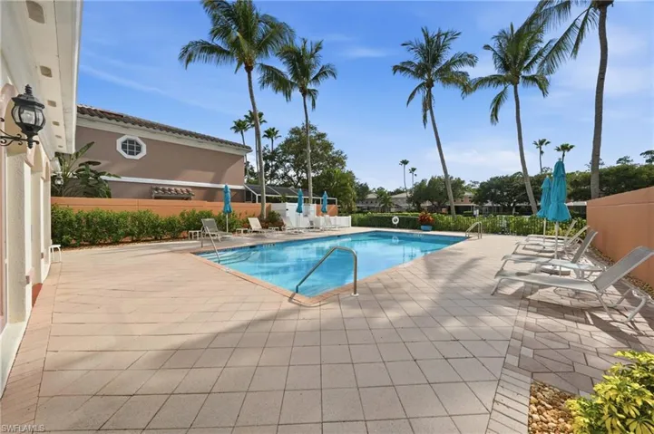 Rectangular swimming pool surrounded by a large paver deck