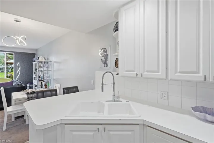 White double basin sink with a high-arc faucet, set into a white countertop