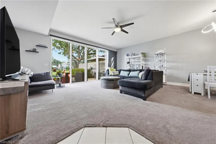 Spacious living area featuring light gray wall paint and plush carpeting