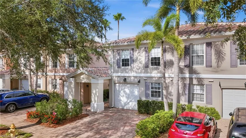 Mediterranean-inspired facade featuring a barrel tile roof, shuttered windows, a covered entry, and an attached garage