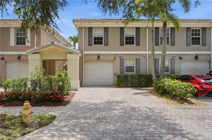 Three-story stucco exterior featuring a covered entry porch