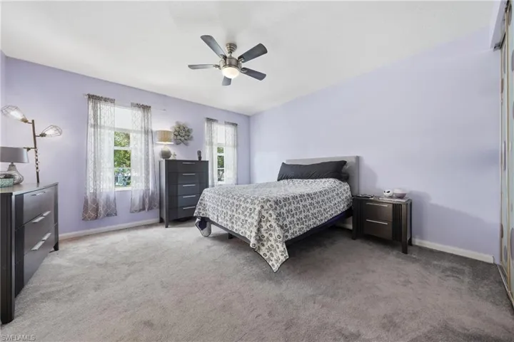 Spacious room featuring light-colored walls and plush carpeting