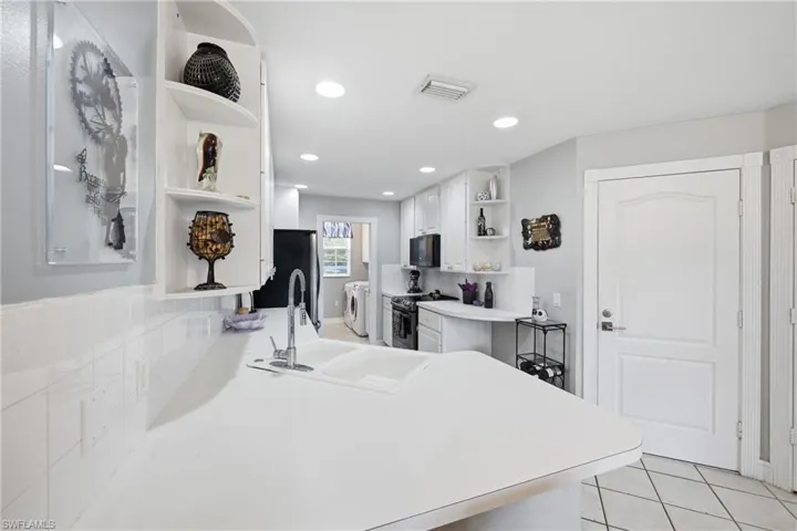 Bright kitchen with white cabinetry and countertops