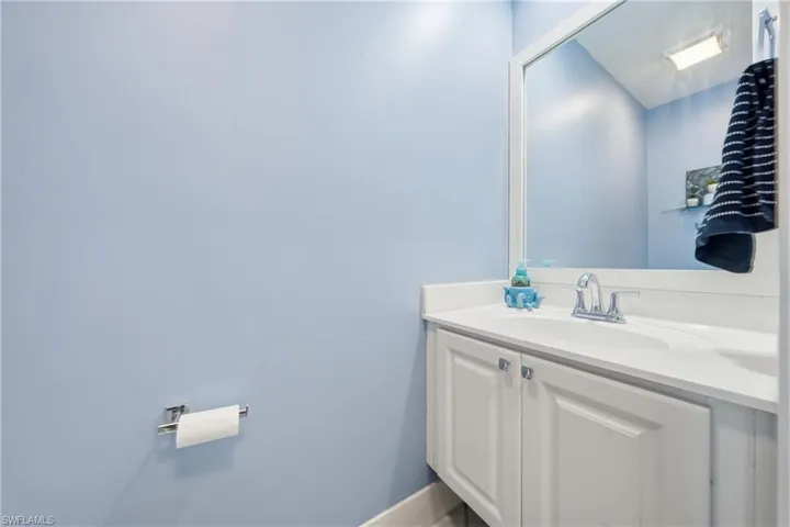 Vanity featuring a white countertop with integrated sink and chrome faucet