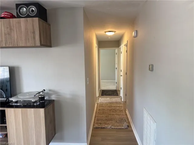 Hallway featuring wood finished floors and baseboards