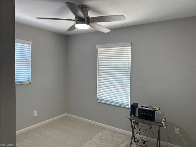 Unfurnished office featuring a ceiling fan and carpet