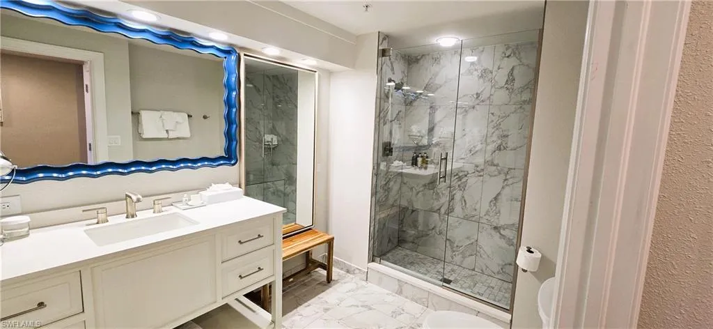 Bathroom featuring vanity, tile patterned flooring, and walk in shower