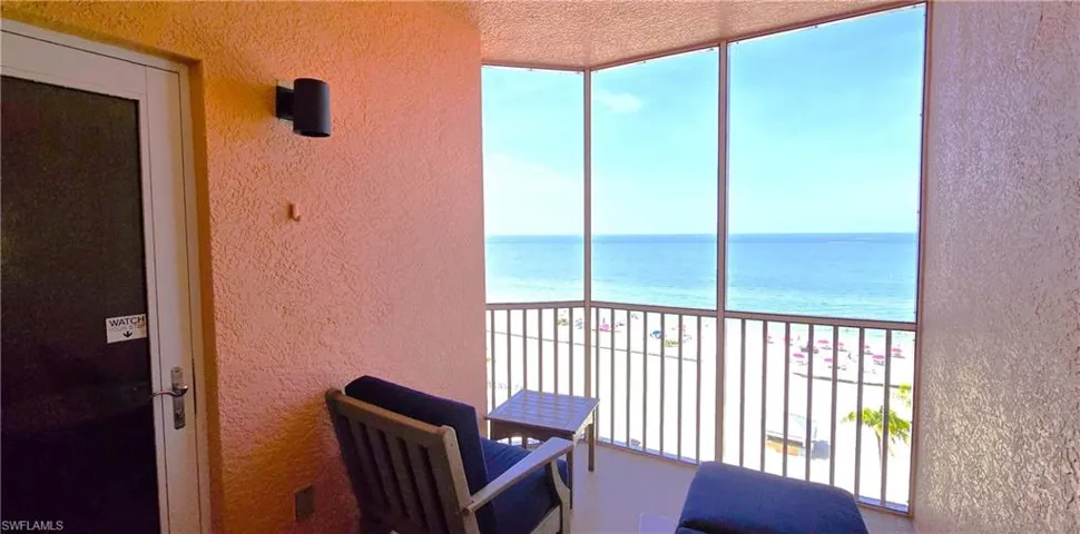Balcony featuring a water view and a view of the beach