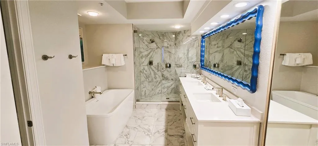 Bathroom with dual vanity, separate shower and tub, and tile patterned flooring