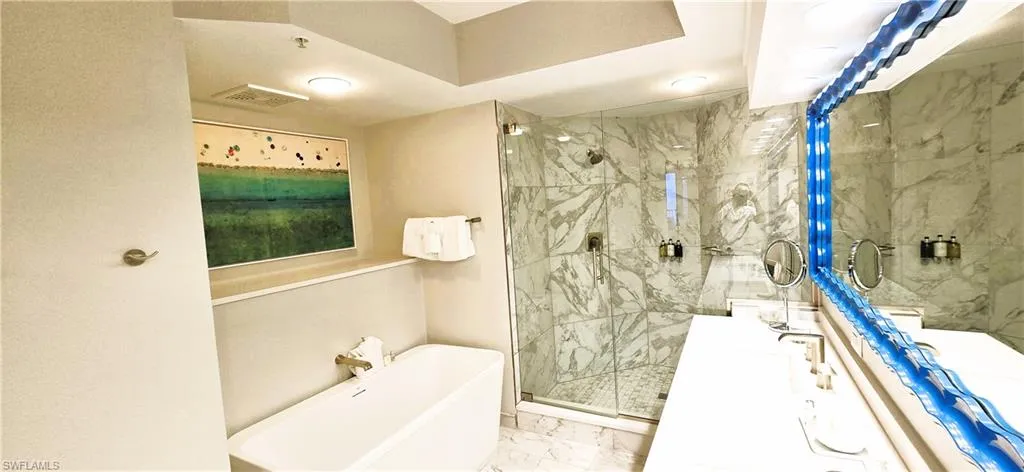 Bathroom featuring tile patterned flooring, walk in shower, and dual bowl vanity