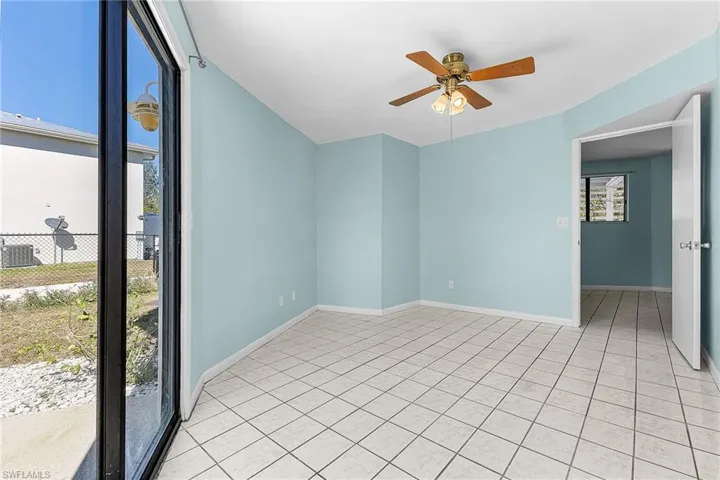 Empty room with ceiling fan and light tile patterned floors