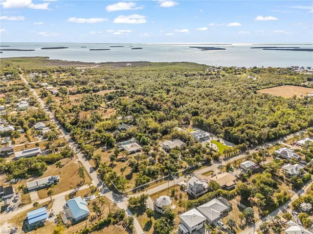 Aerial view of property's location with a nearby body of water and nearby suburban area