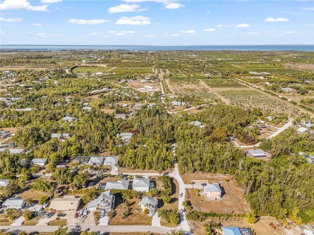 Aerial view of property and surrounding area with a nearby body of water