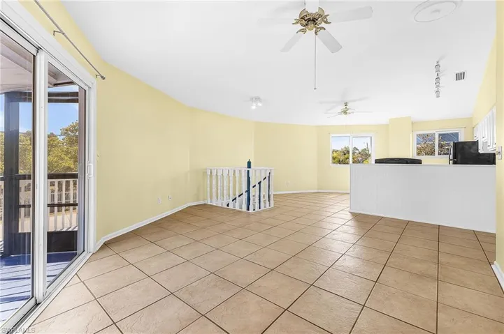 Unfurnished room with light tile patterned flooring, track lighting, and ceiling fan