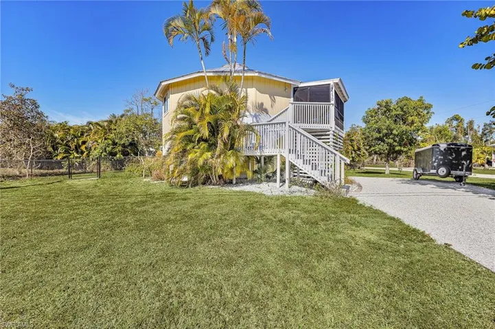 View of side of home featuring stairway and a deck